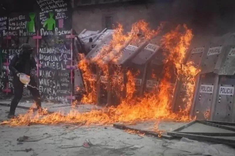 AMLO muestra manifestante arrojando gasolina a policía en el 8M